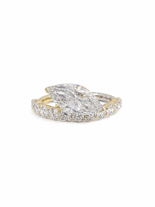 Diamond ring with a pear-shaped center stone on a white background